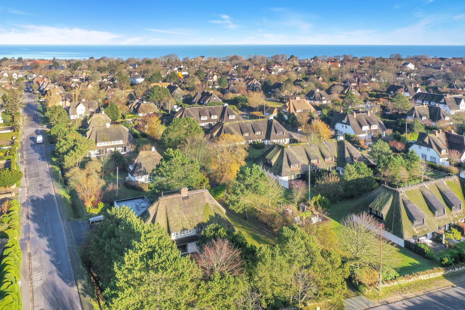 Dorf mit Strohdächern und Blick auf das Meer.
