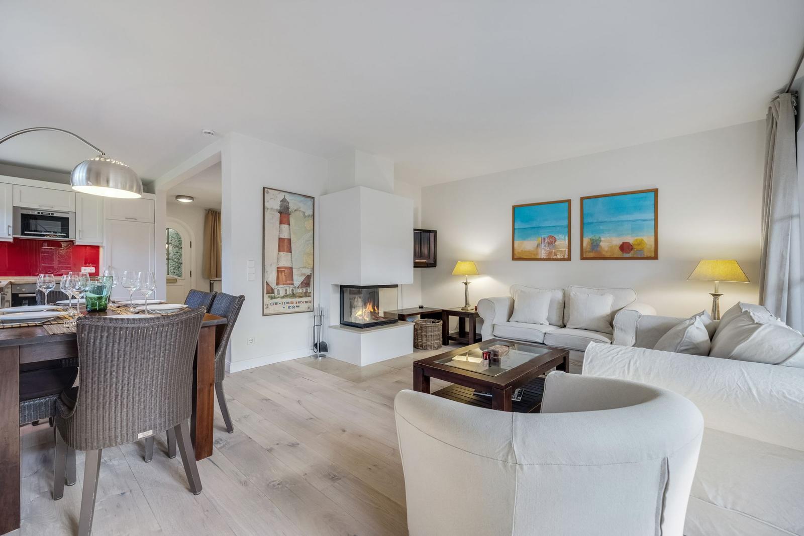 Living and dining area with fireplace, sofa, and dining table.