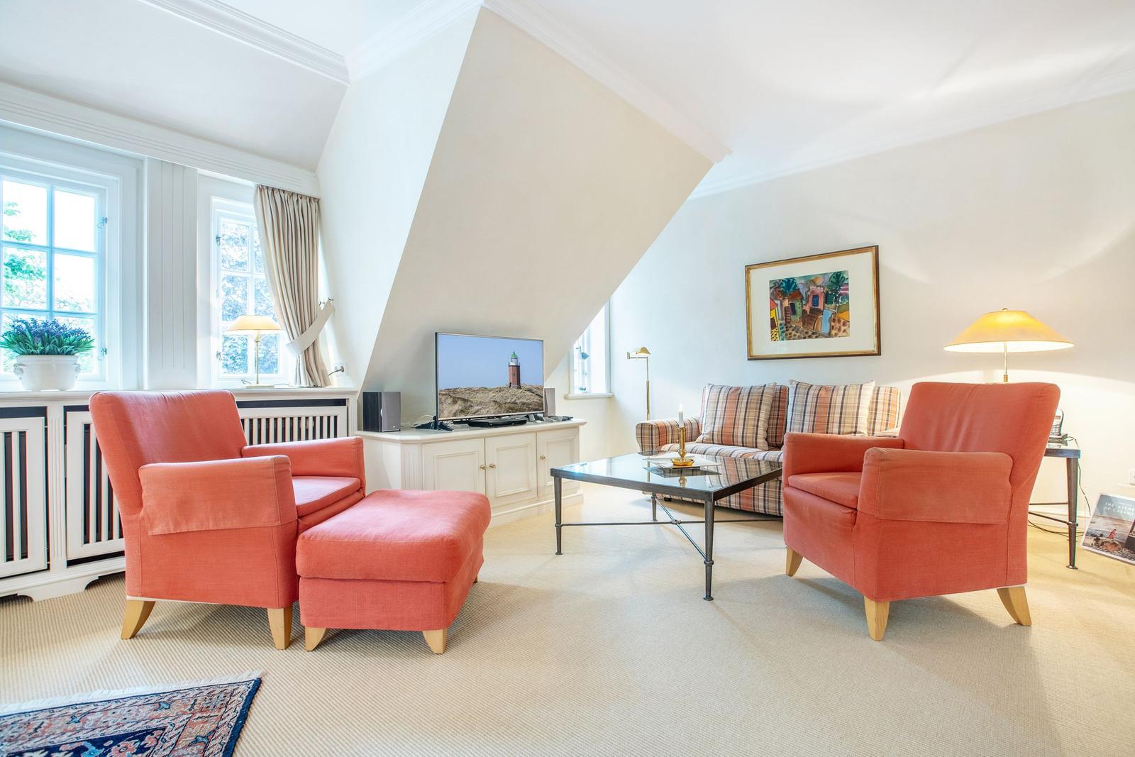 Living room with two orange chairs, sofa, and TV.