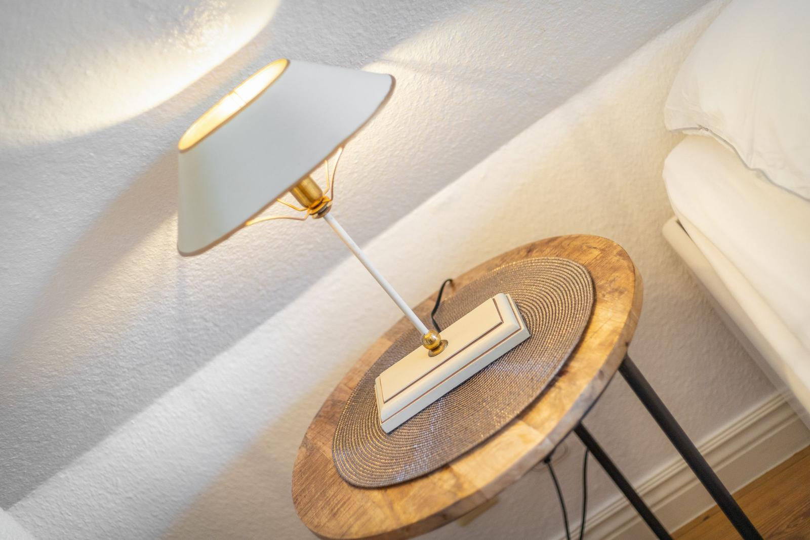 Lampe auf runden Tisch neben Bett