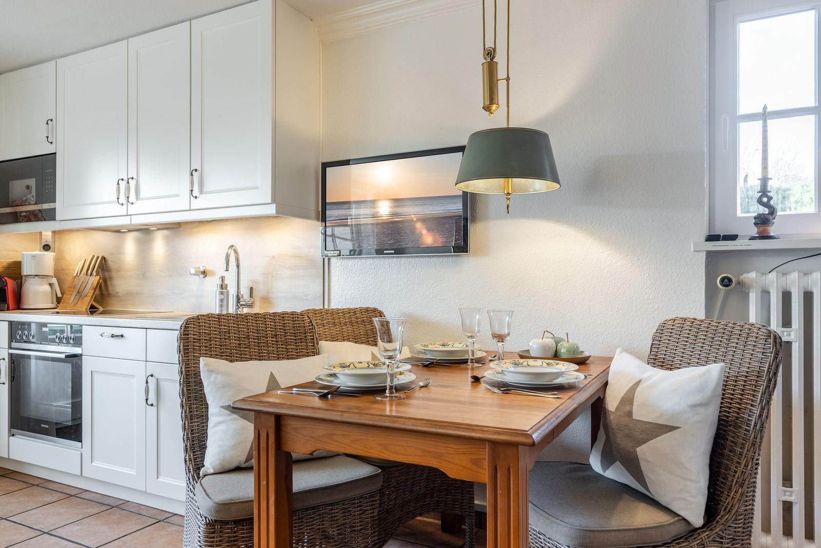 Esszimmer mit Tisch, Stühlen und Küchenzeile