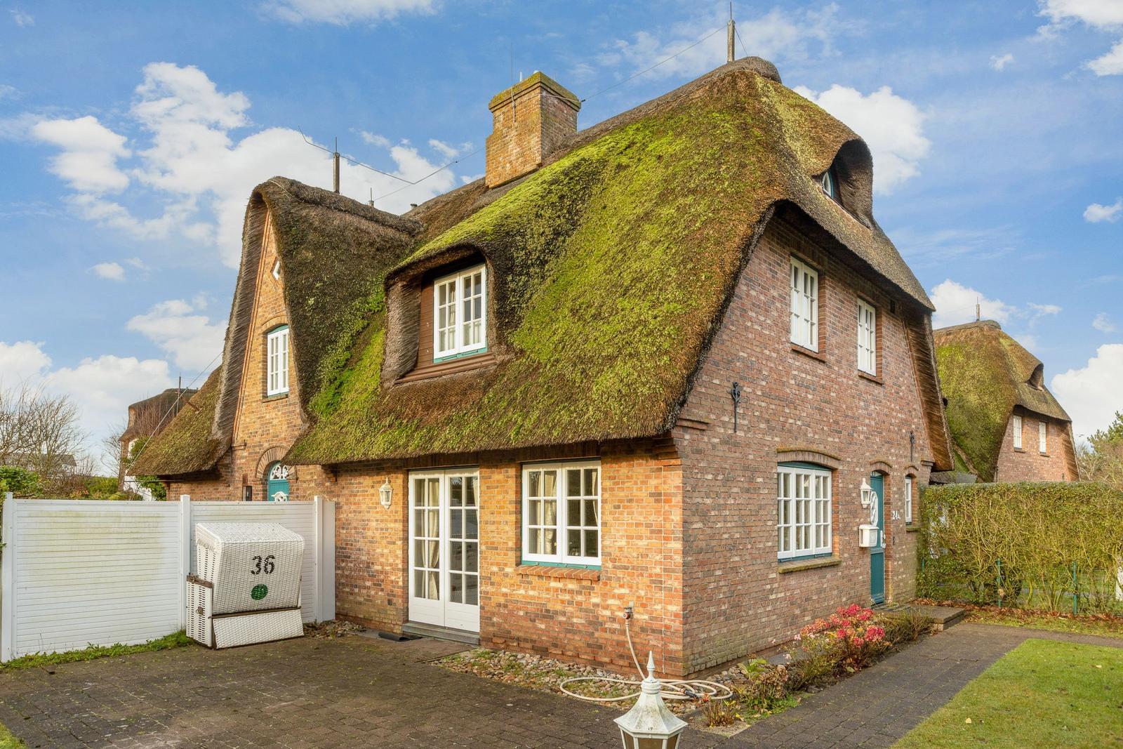House with thatched roof and brick facade.
