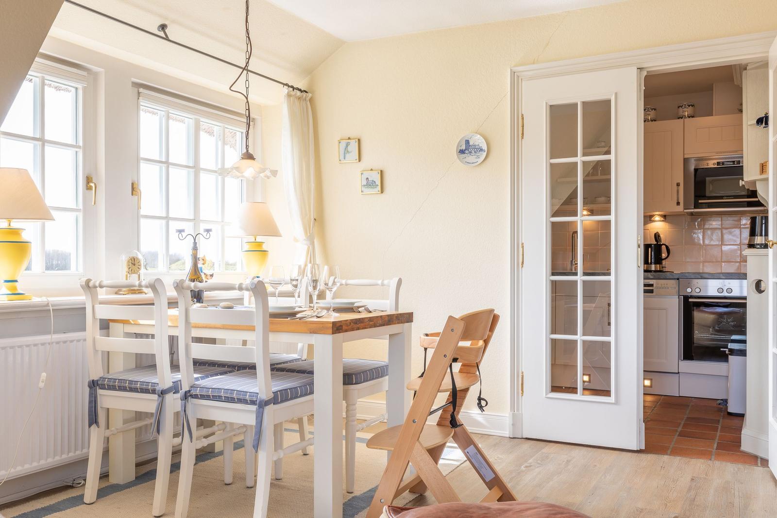 Dining room with table, chairs, and view into the kitchen.