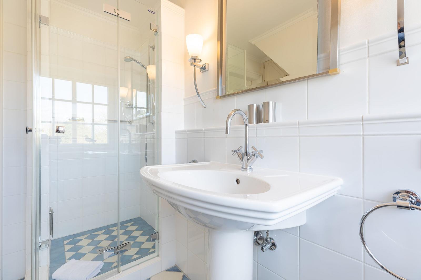 Bathroom with shower, sink, and mirror.