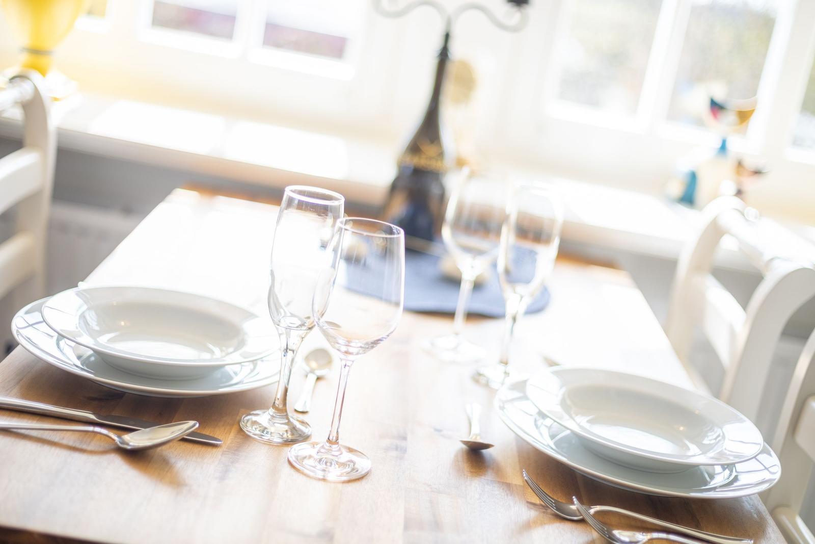 Table with dishes and glasses near window