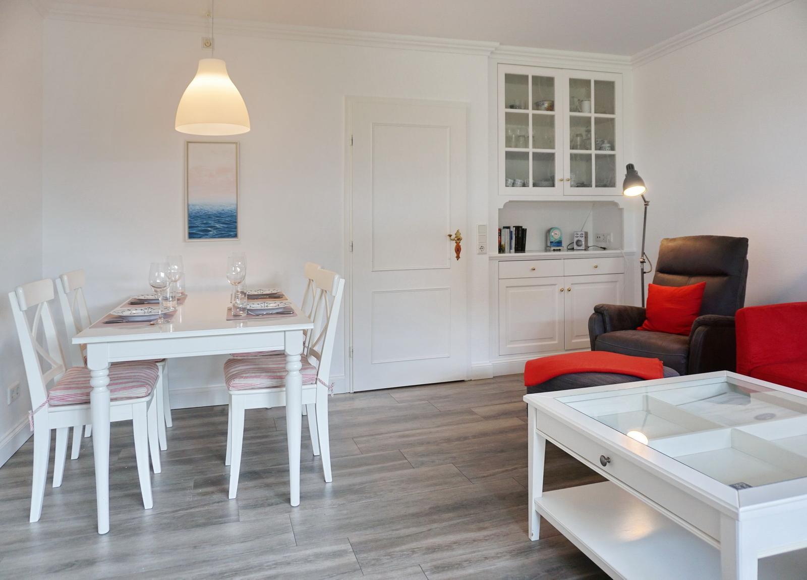 Essbereich mit Tisch und Stühlen, Wohnbereich mit Sofa und Couchtisch.