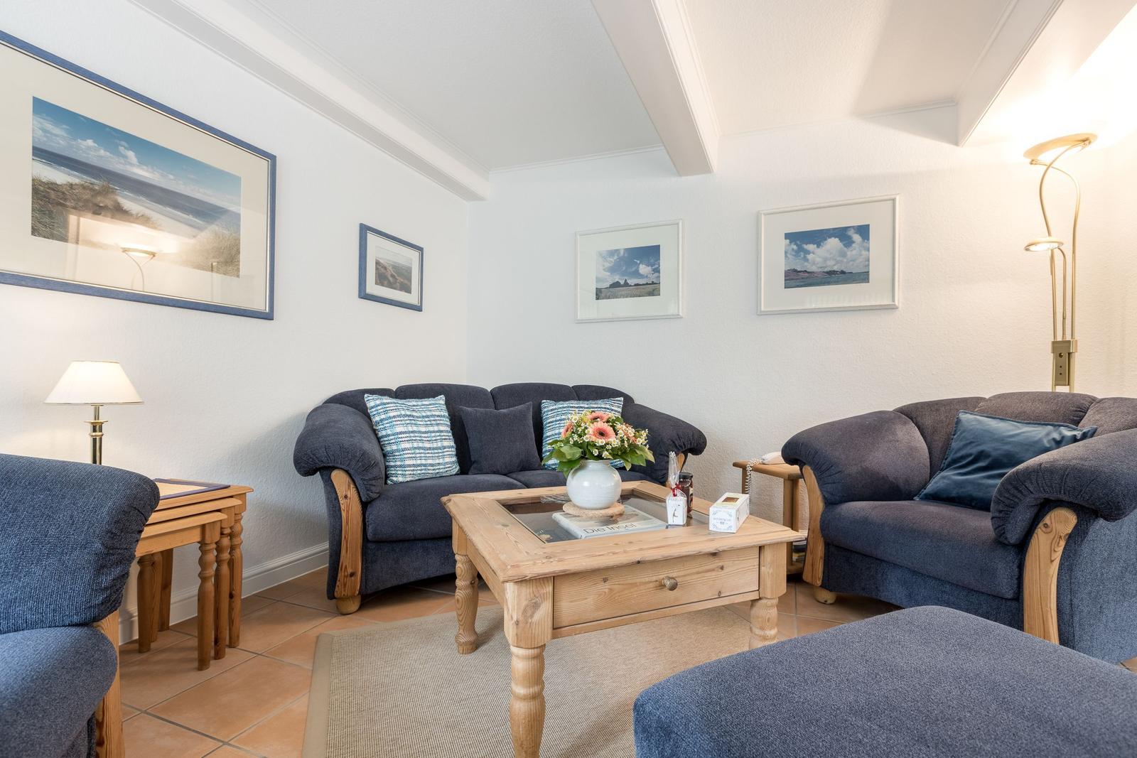 Wohnzimmer mit zwei Sofas, Holztisch und Wandbildern.