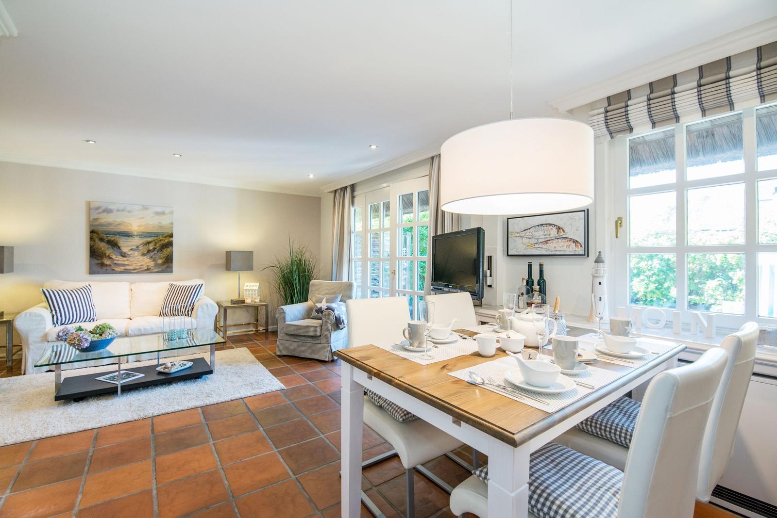 Esszimmer mit Tisch und Stühlen, Wohnzimmer mit Sofa und Fernseher