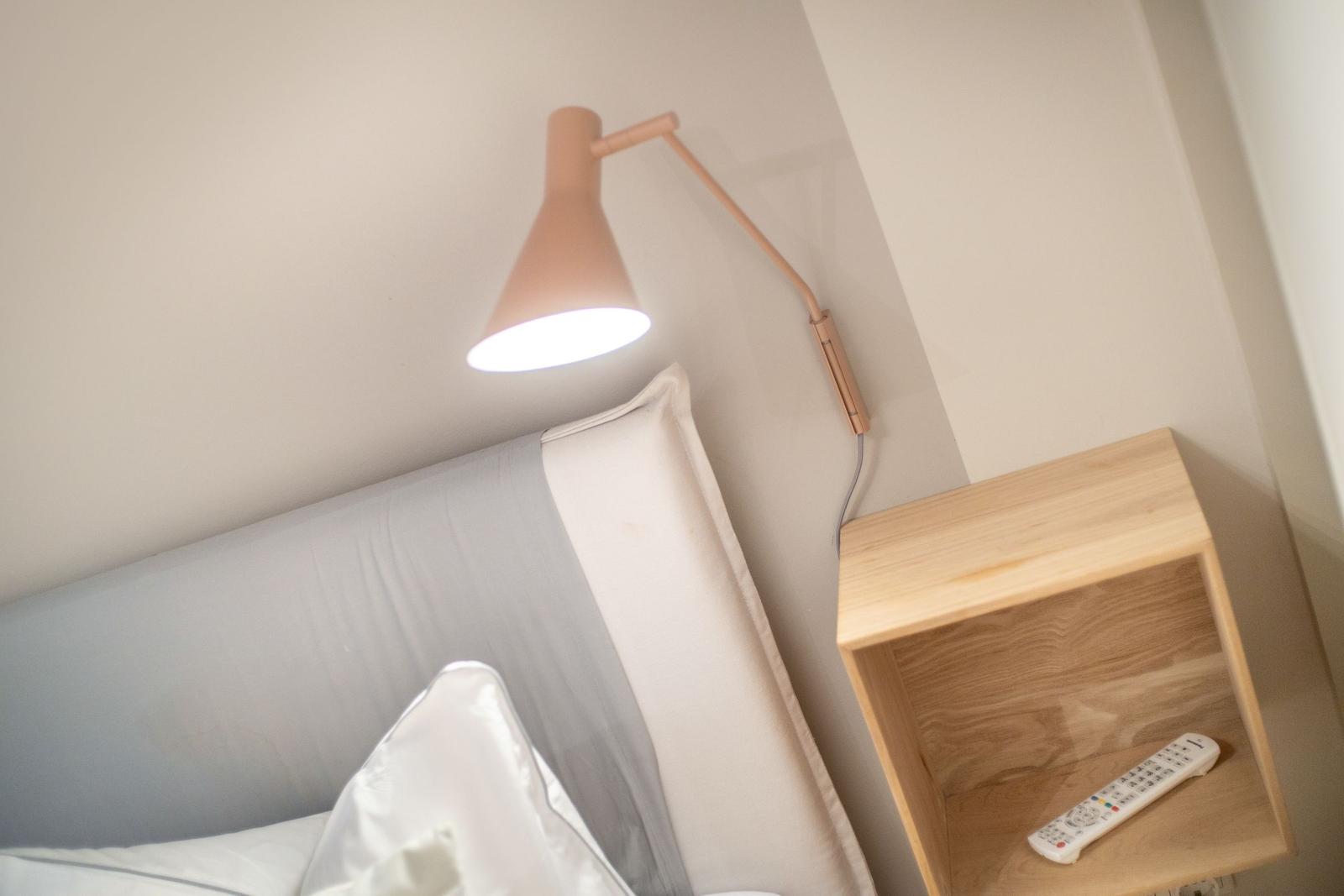 Schlafzimmer mit Nachttisch und Wandlampe