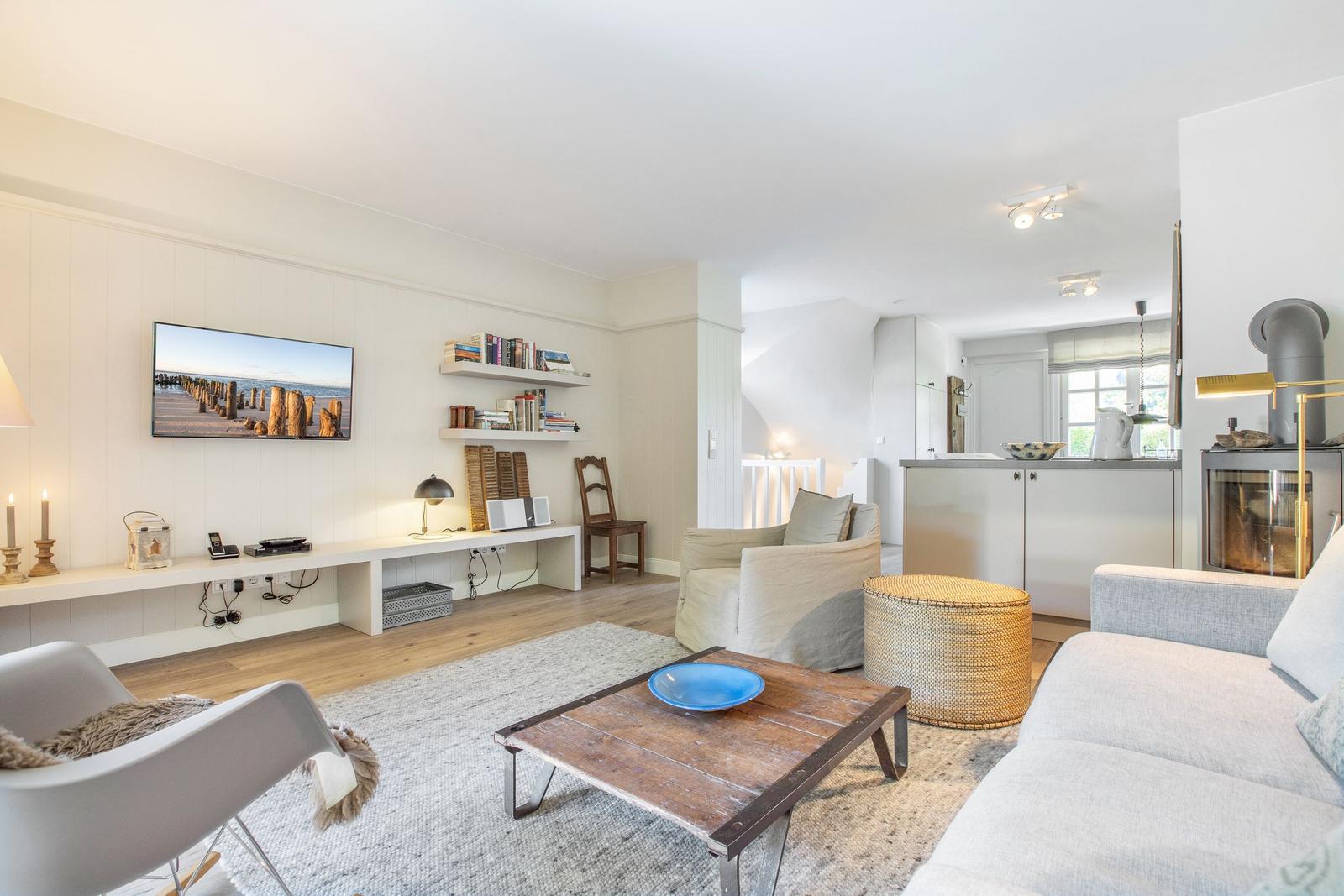 Wohnzimmer mit Sofa, Couchtisch und Fernseher an der Wand.