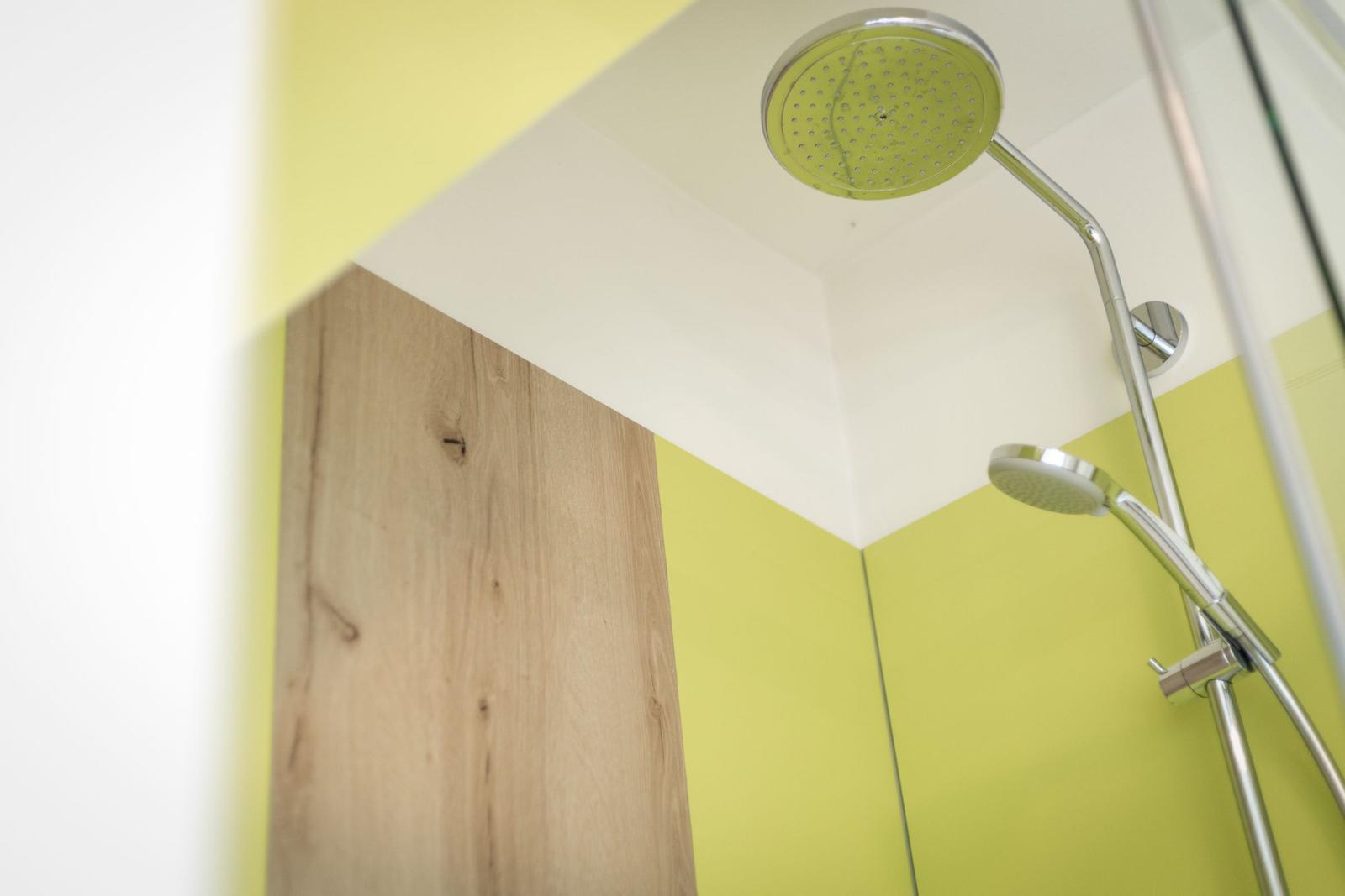 Dusche mit zwei Duschköpfen und gelben Wänden