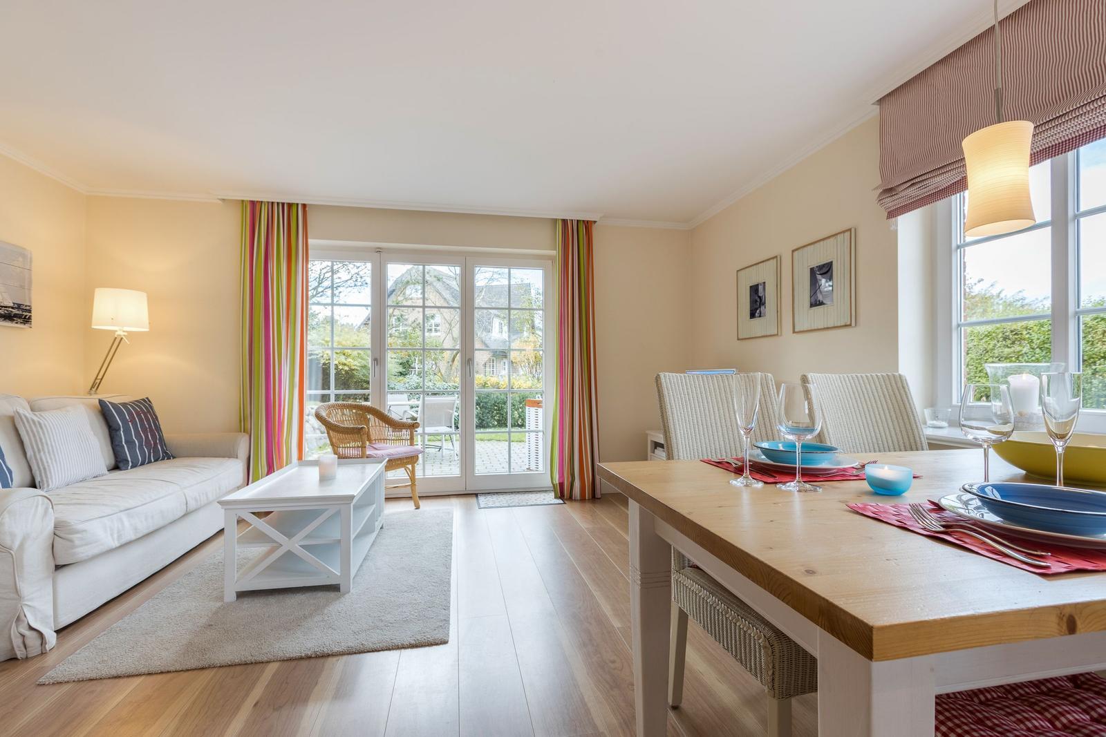 Living and dining area with table, sofa, and terrace door.