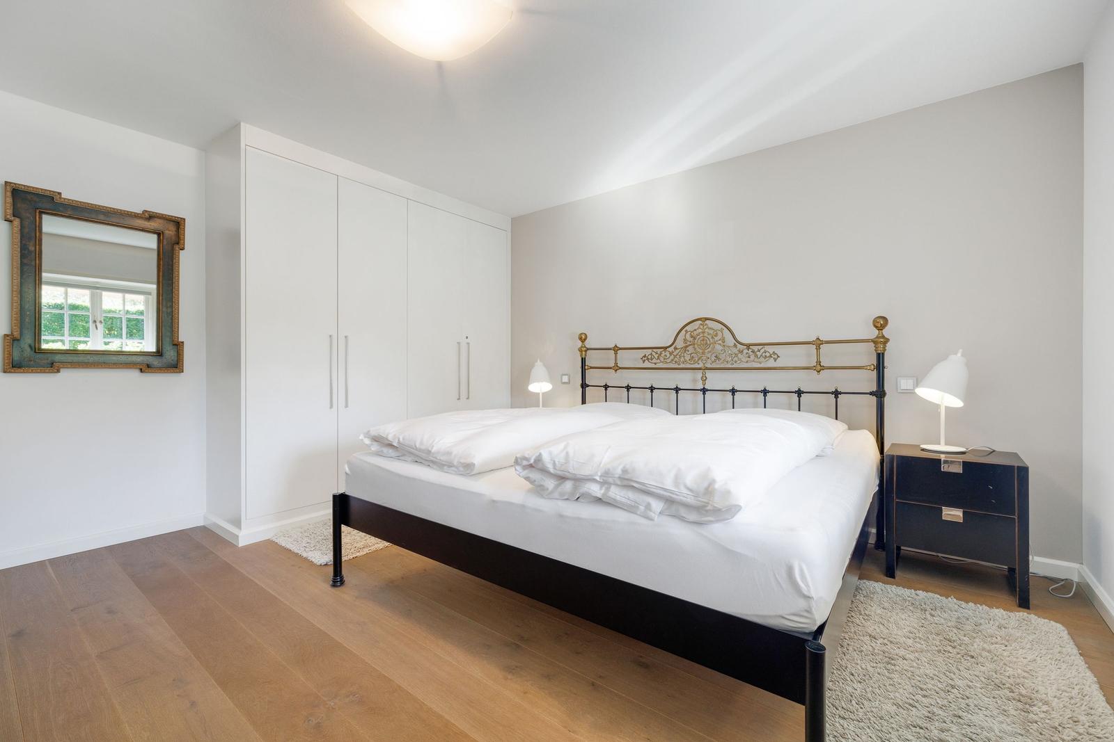 Bedroom with bed, wardrobe, and bedside table.
