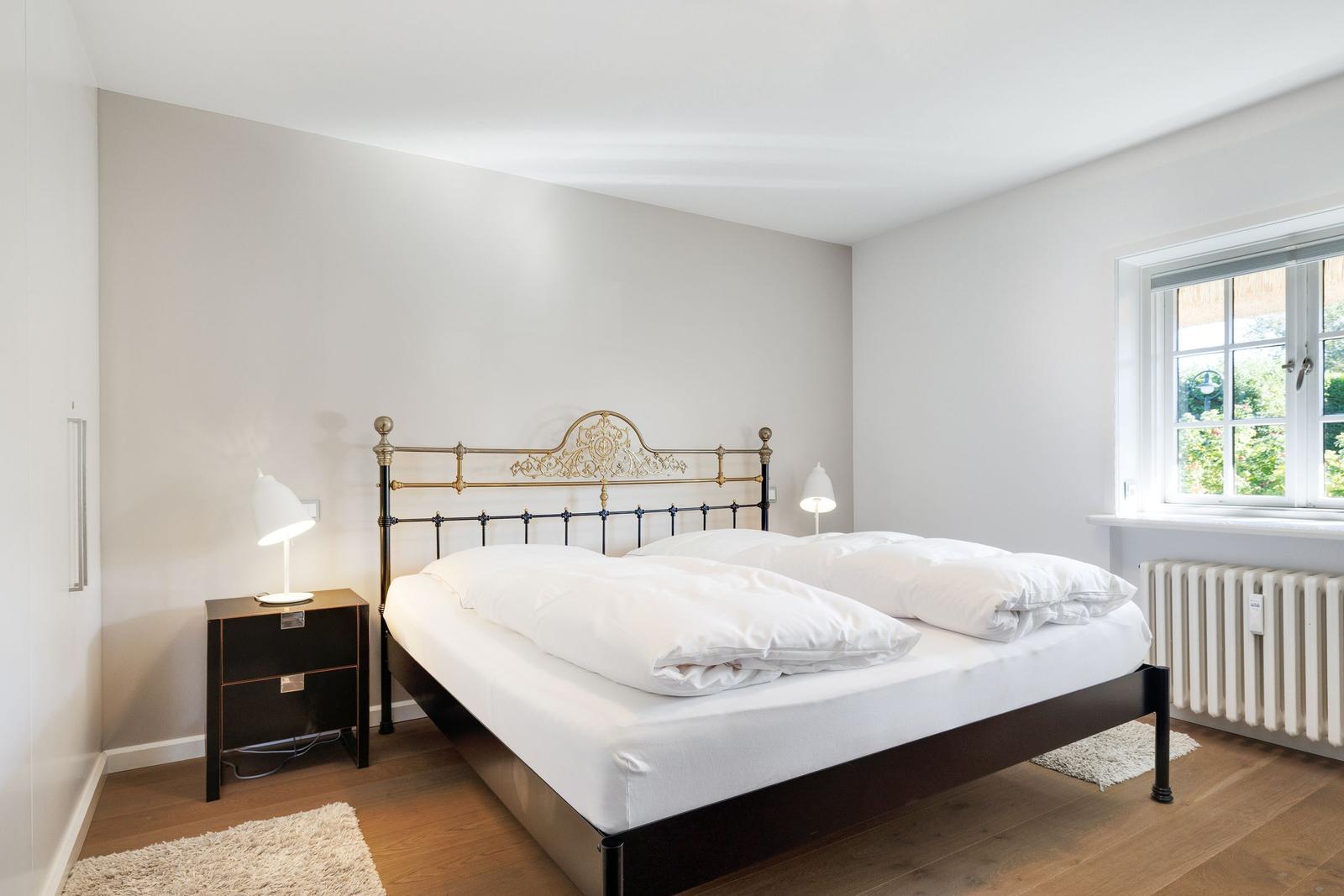 Bedroom with double bed, nightstand, and window.