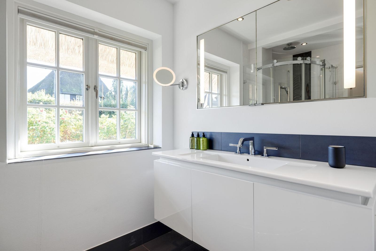 Bathroom with window, mirror, and sink