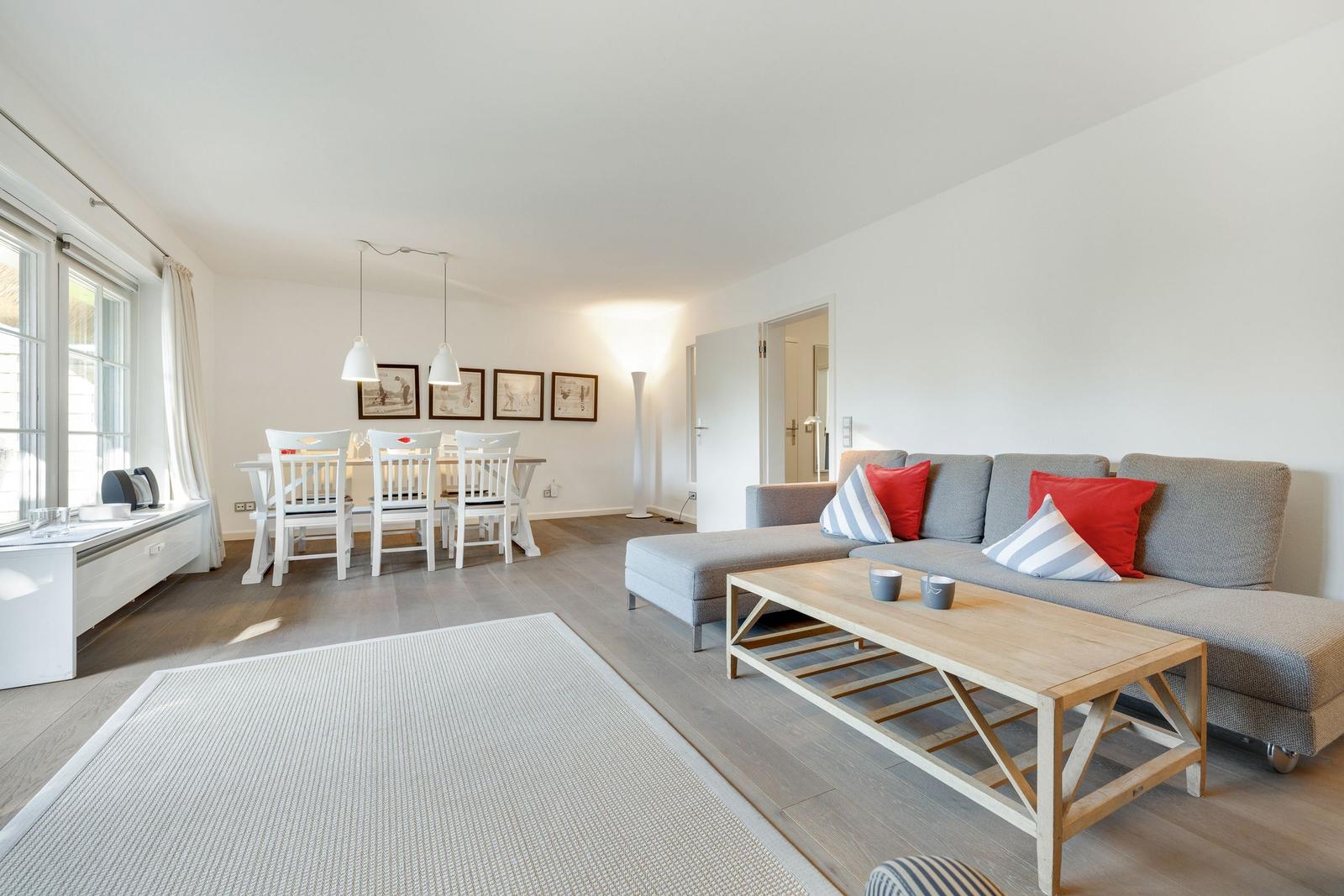 Living and dining area with sofa, table, and chairs.