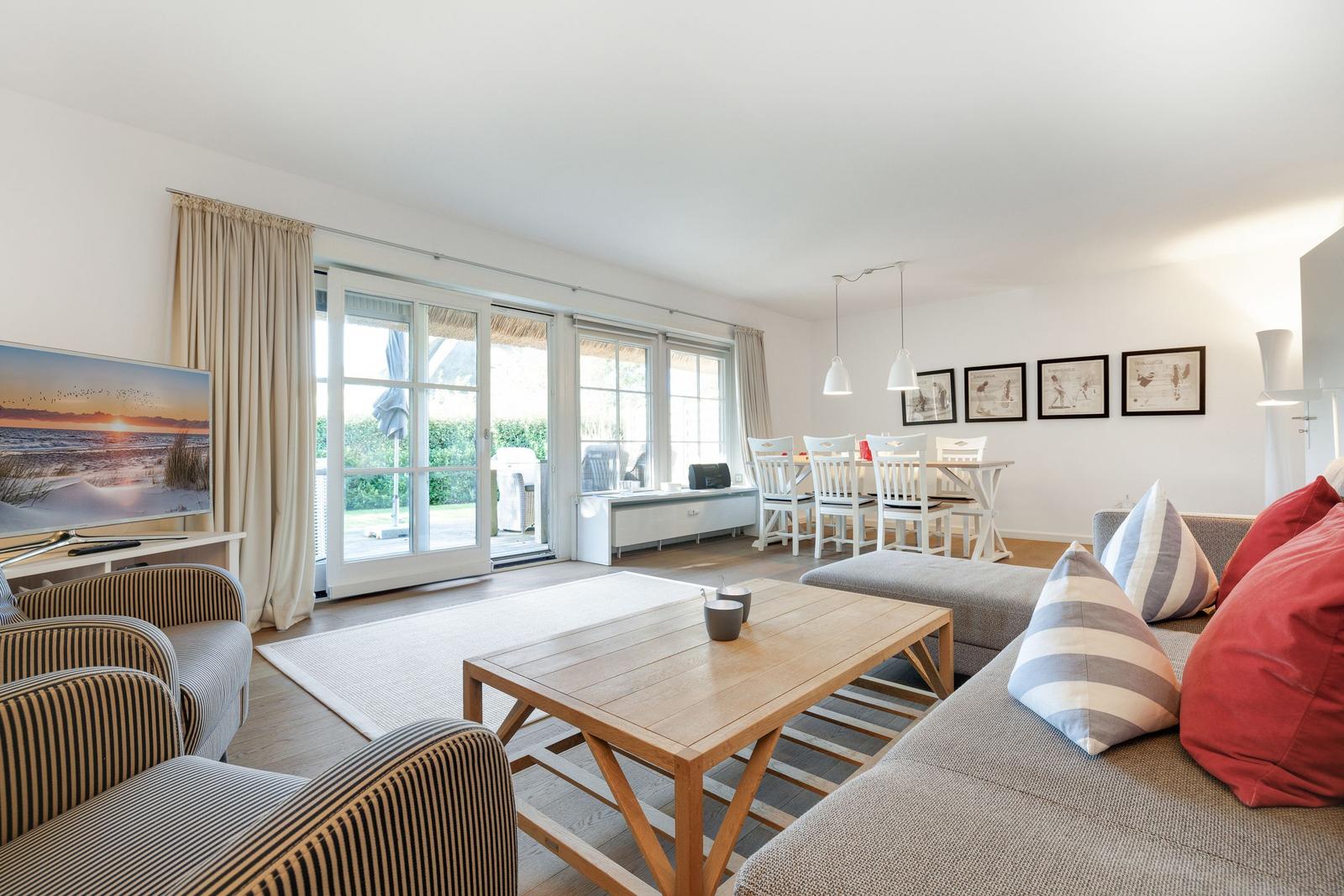 Living and dining area with sofa, coffee table, and TV. Access to terrace and garden.