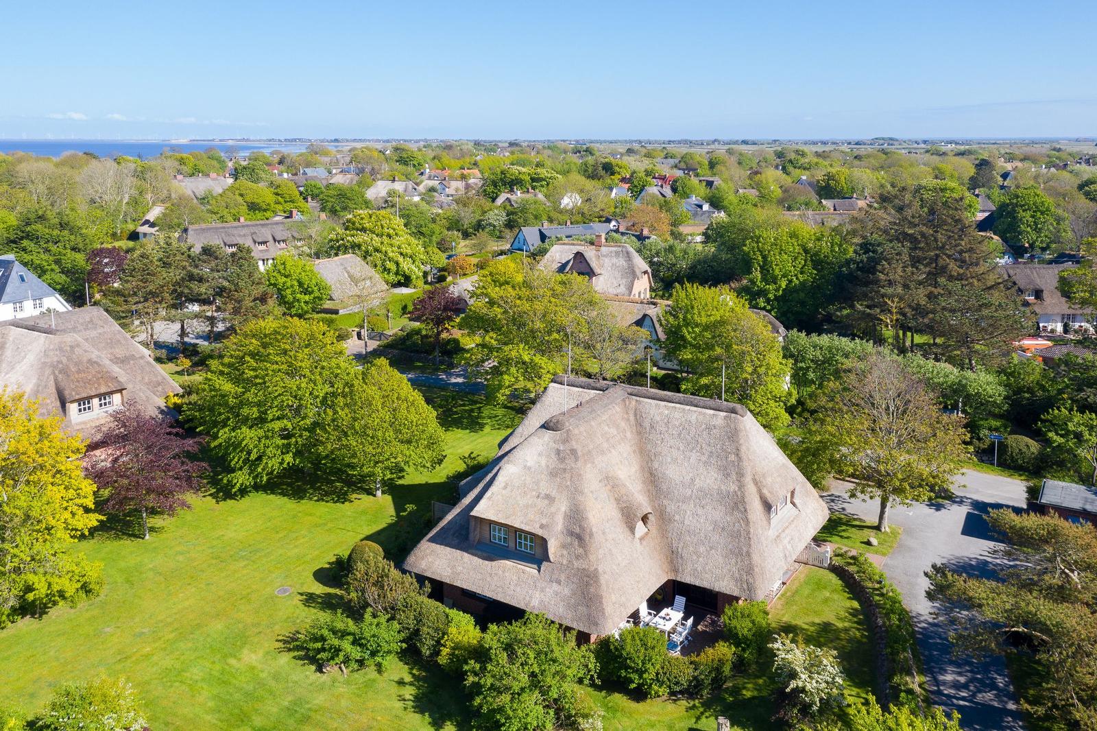 Thatched house with garden. View of the lake in the background.