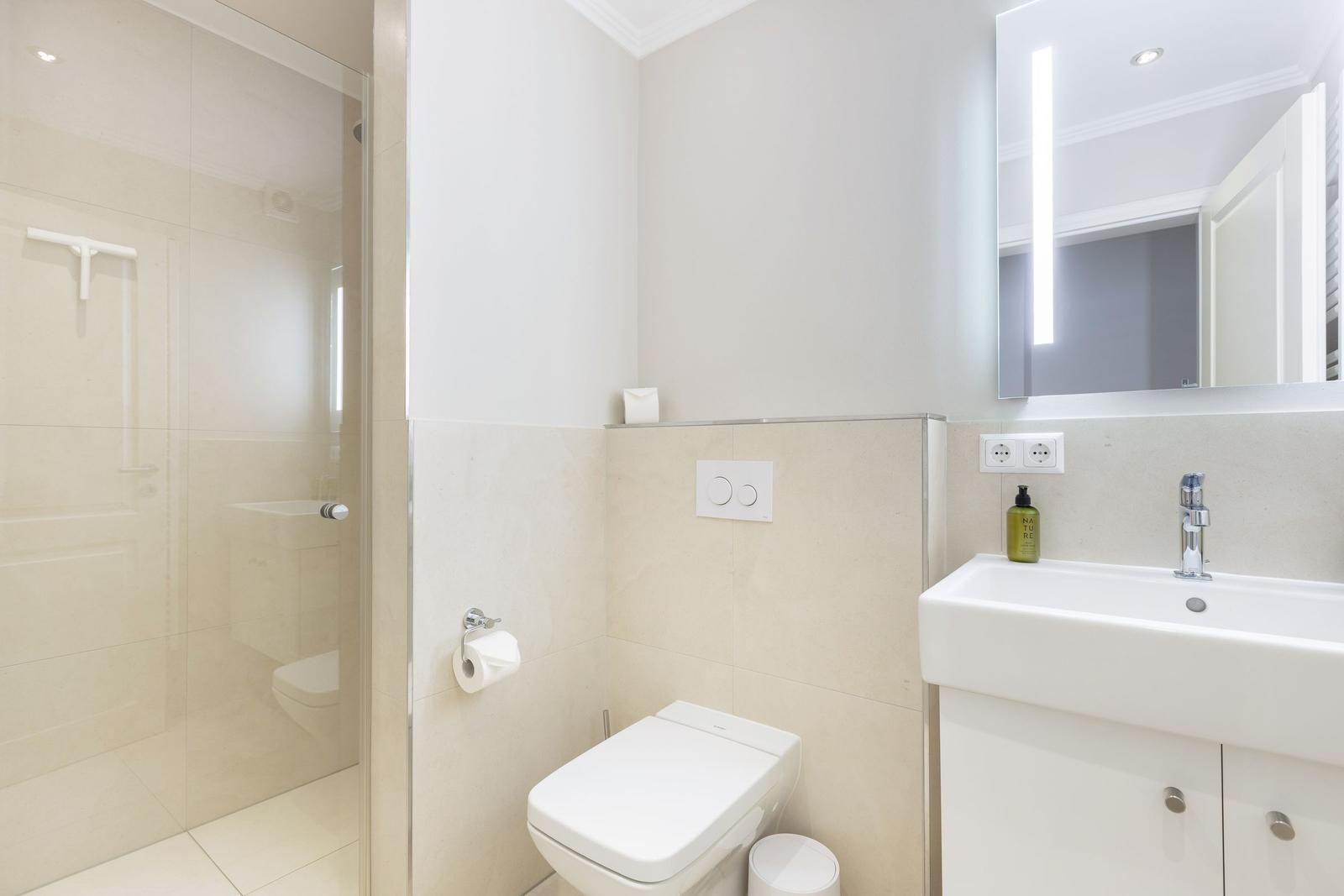 Bathroom with shower, toilet, and sink.