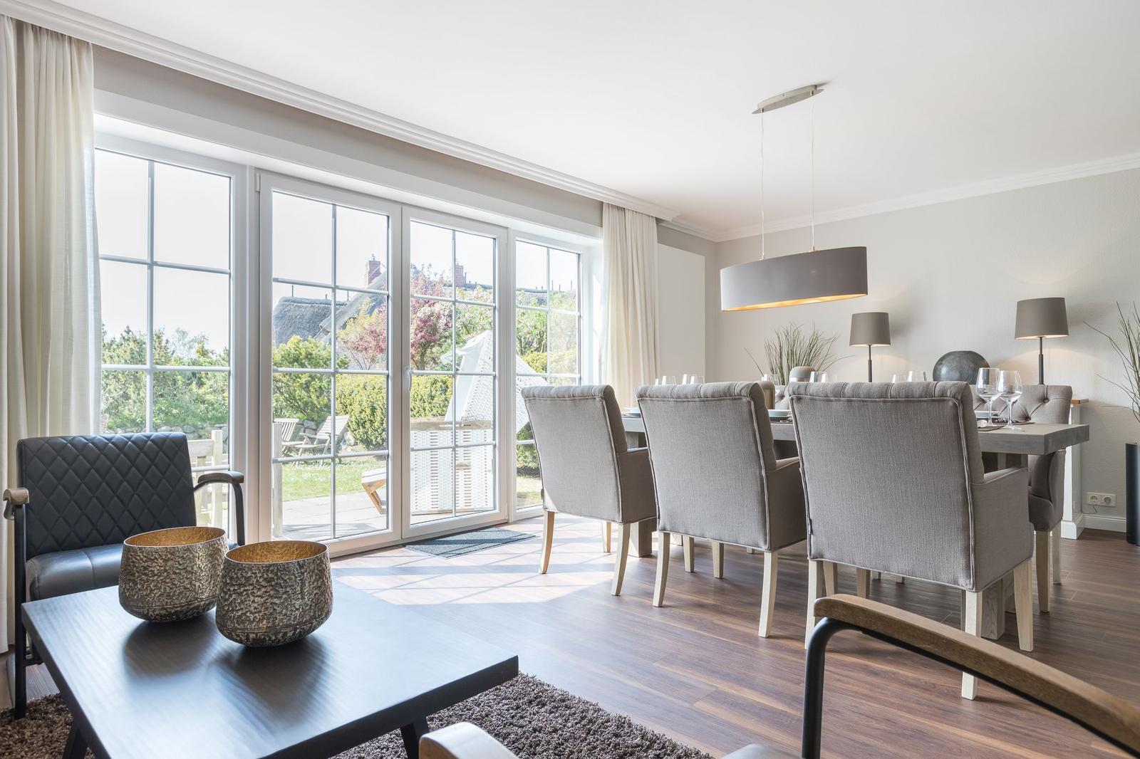 Großes Esszimmer mit Tisch, Stühlen und Blick auf Garten