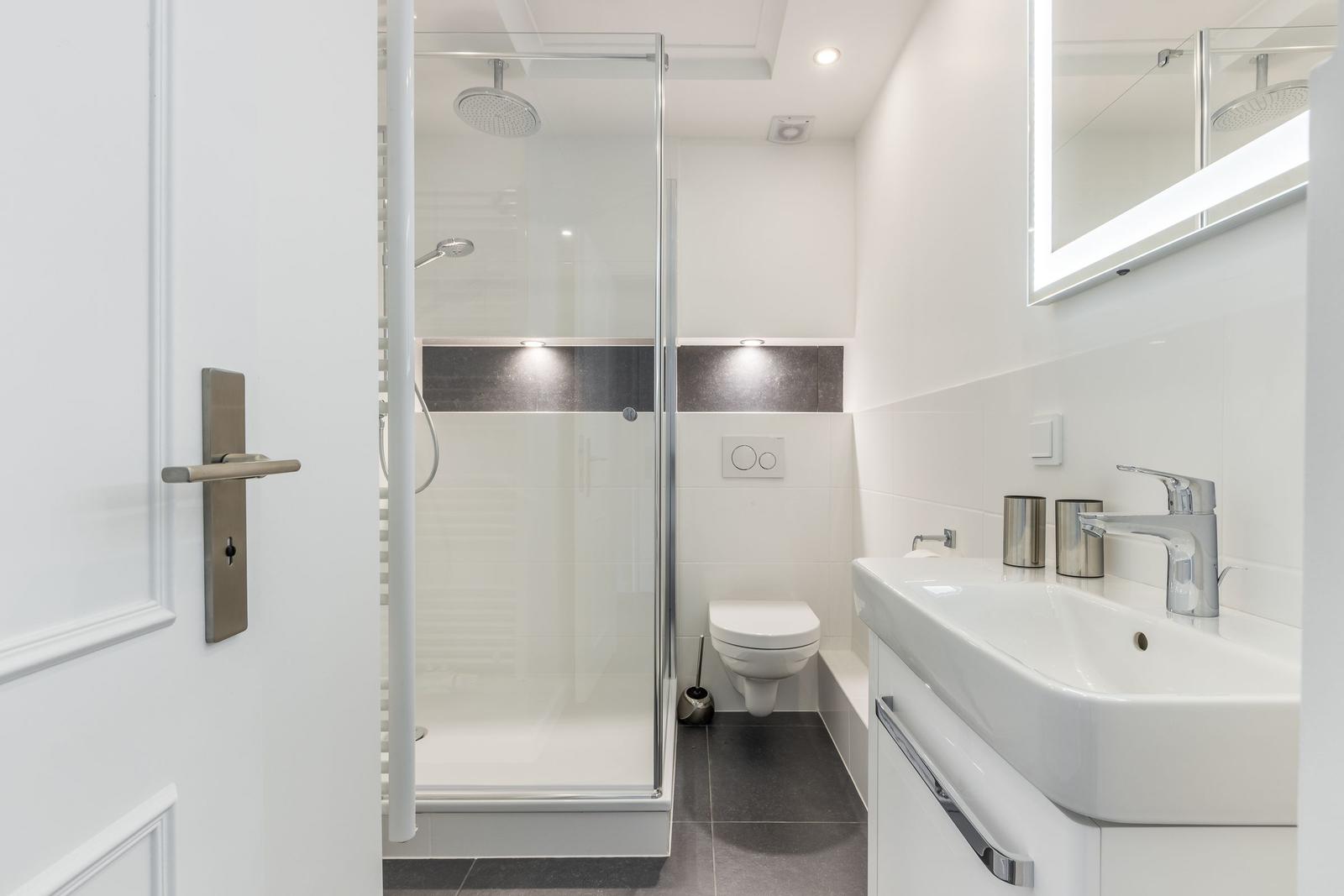 Dusche, Toilette und Waschbecken in moderner Badezimmerausstattung.