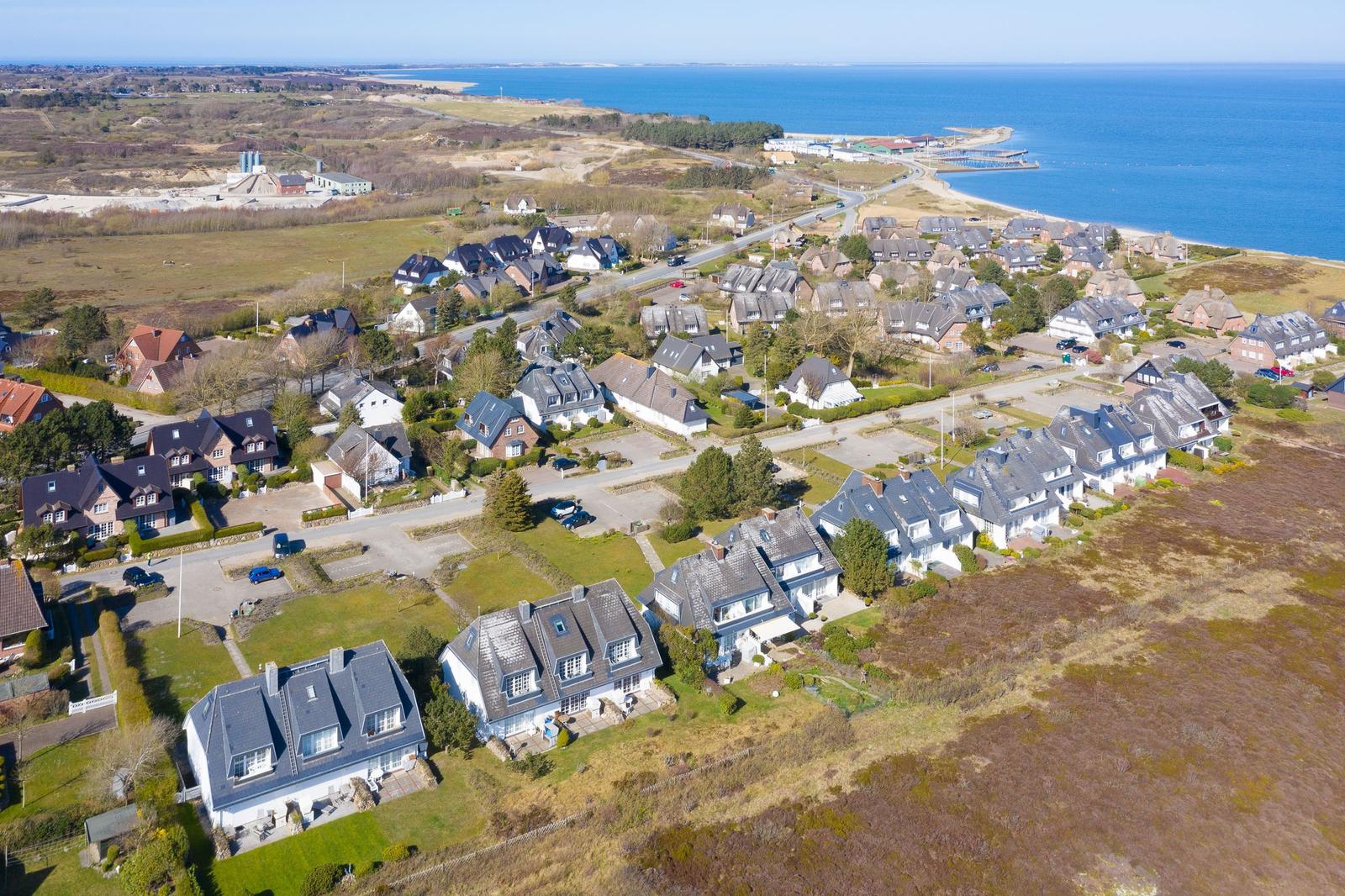 Luftbild von Häusern am Meer mit Strand und Grünflächen