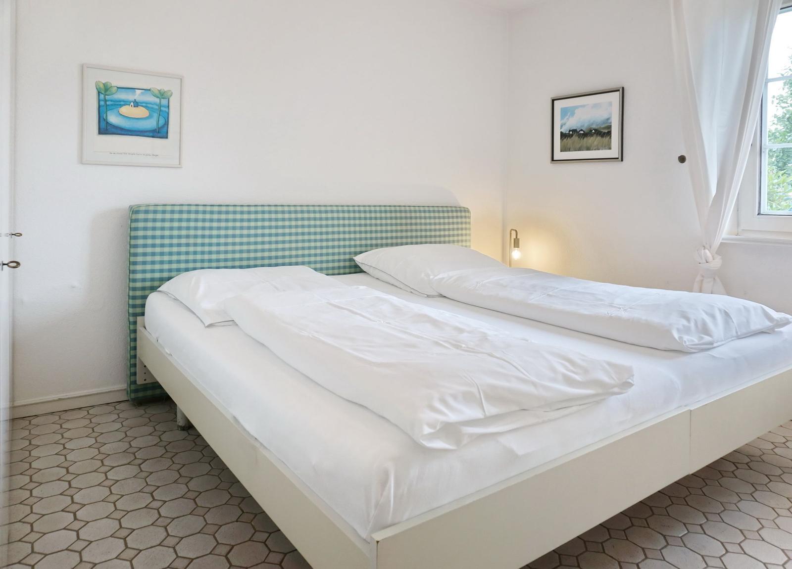 Bedroom with bed, wall art, and window