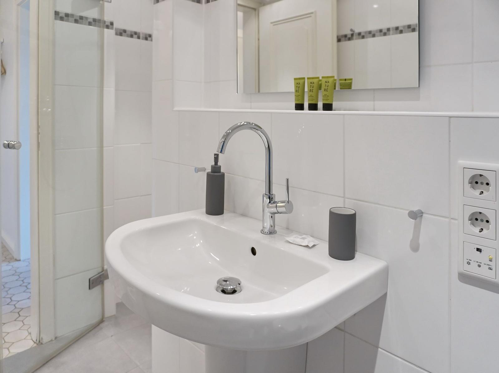 Sink with mirror and shower in bathroom