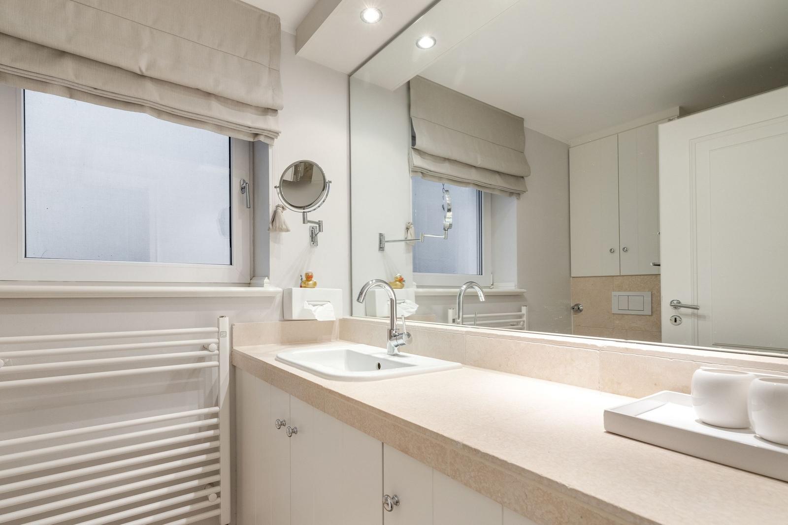 Bathroom with sink, mirror, and window