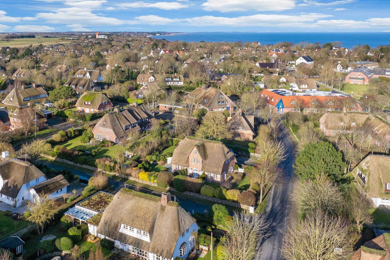 Village with thatched houses and view of the sea