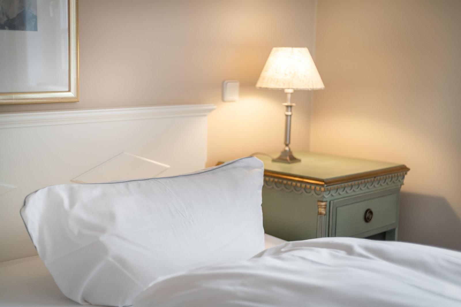 Bed headboard with pillow and bedside table with lamp