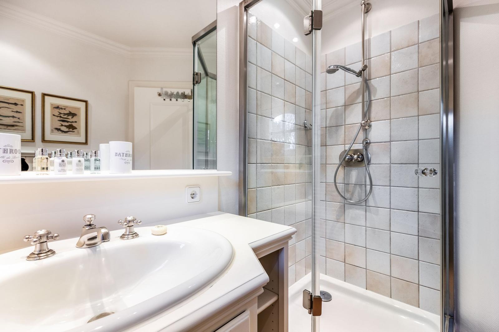 Bathroom with shower, sink, and mirror