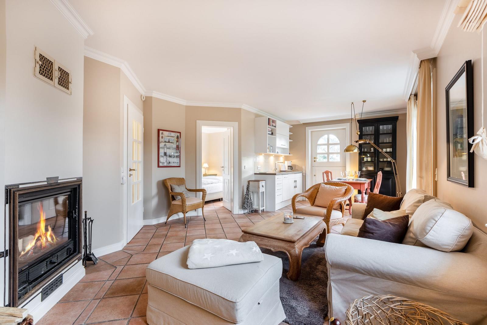 Living room with fireplace, sofa, and dining table in background.