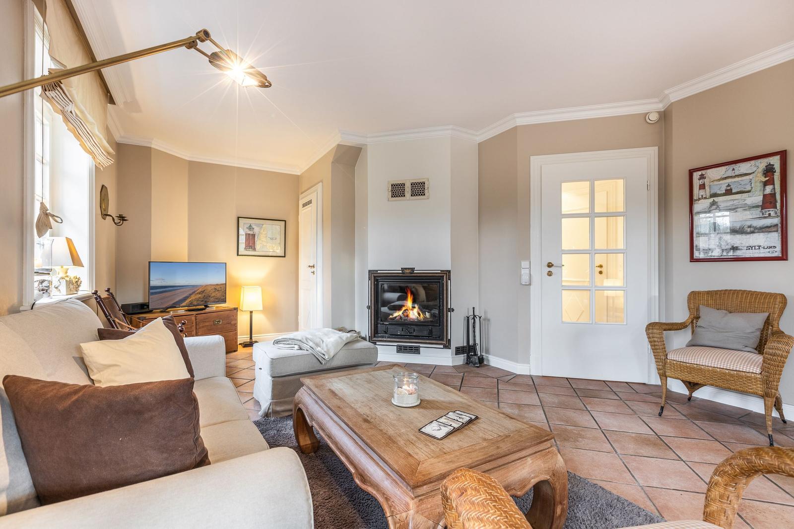 Living room with fireplace, sofa, coffee table, and wicker chair