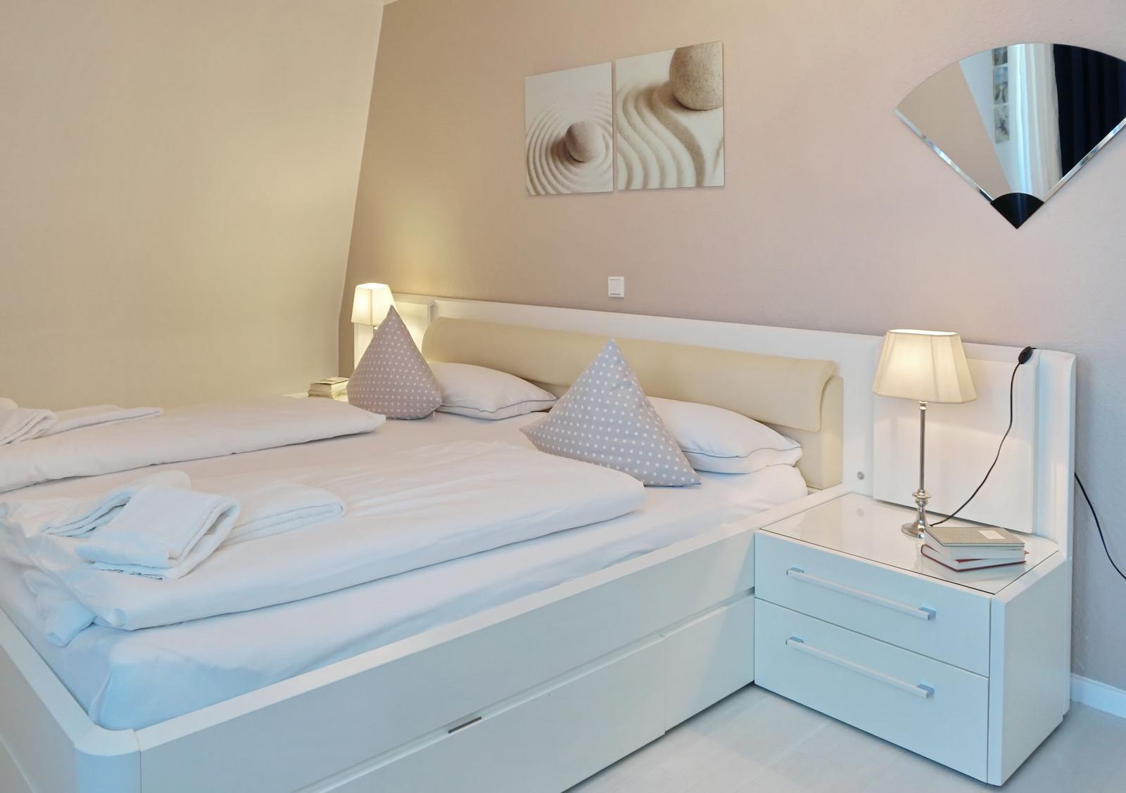 Bedroom with bed, nightstand, and wall art.