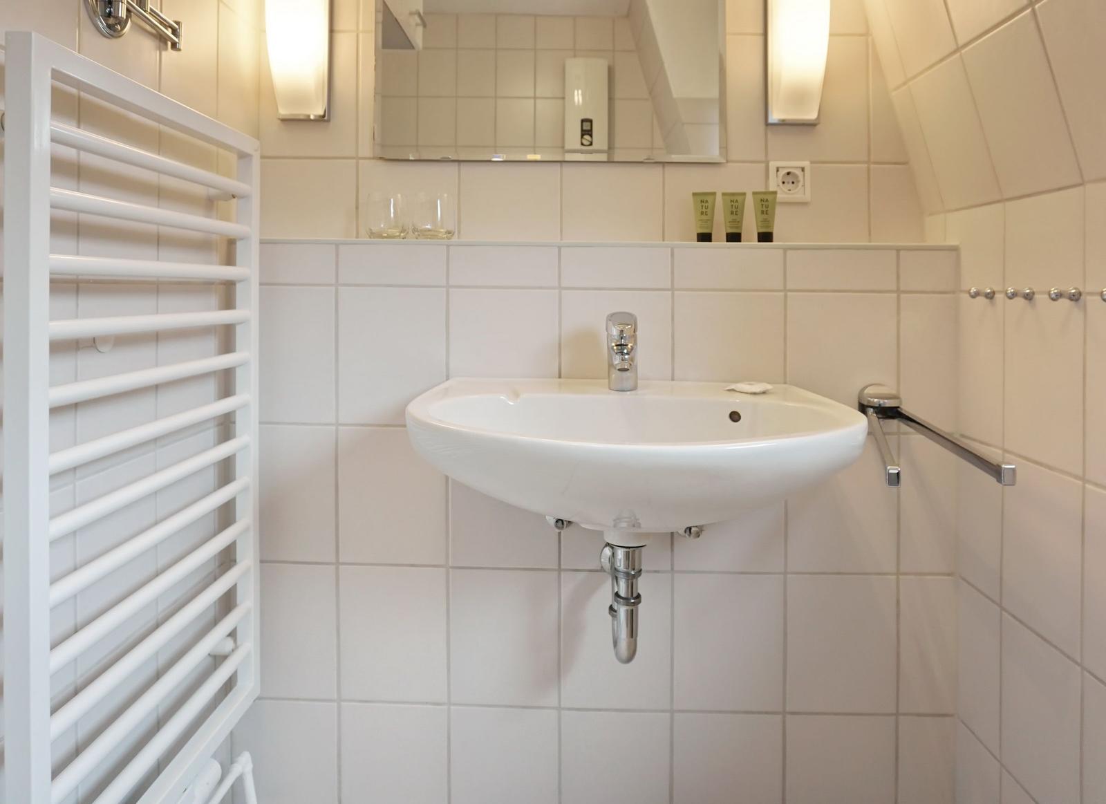 Bathroom with sink, mirror, and heater