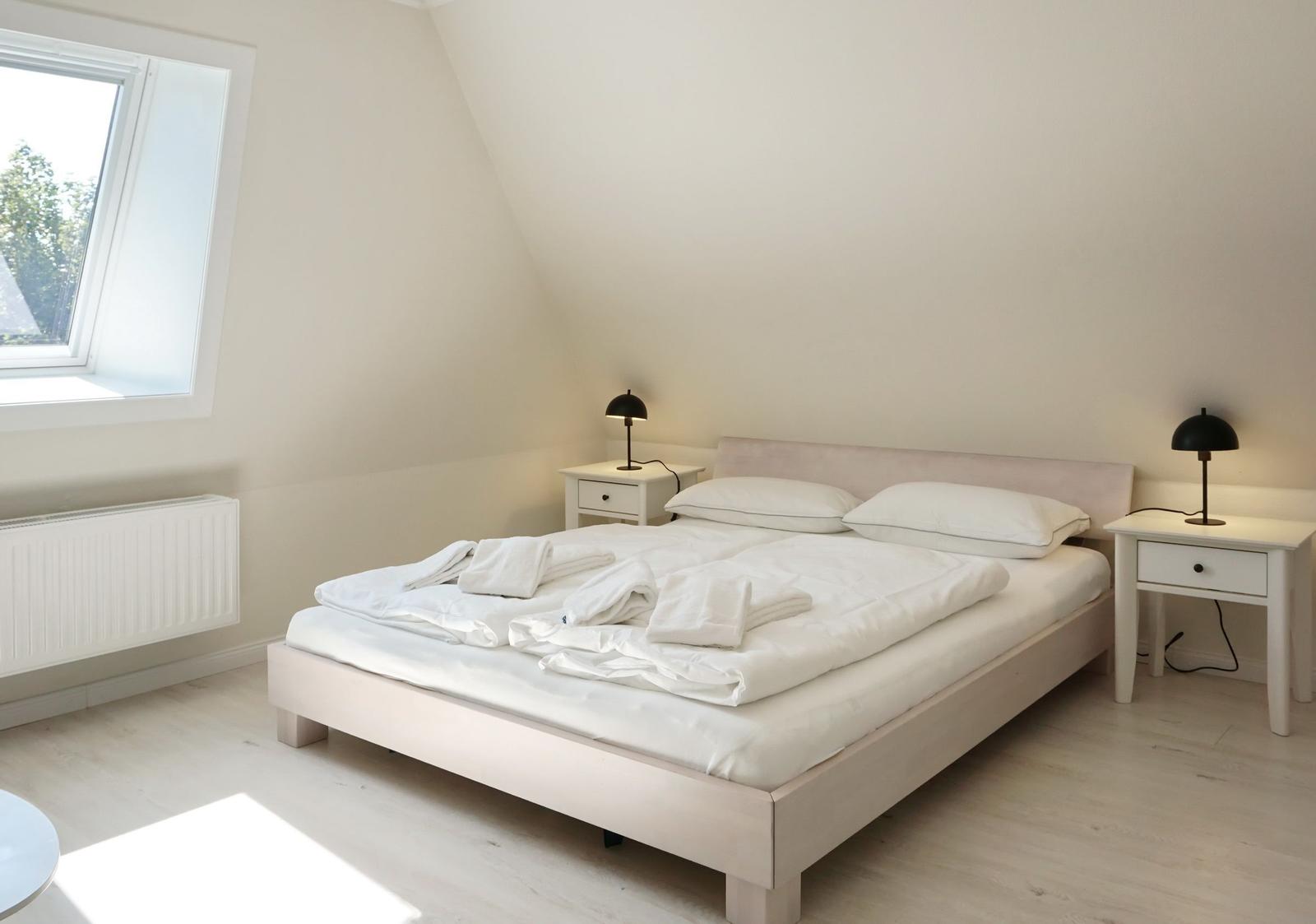 Bedroom with double bed, two nightstands, and window