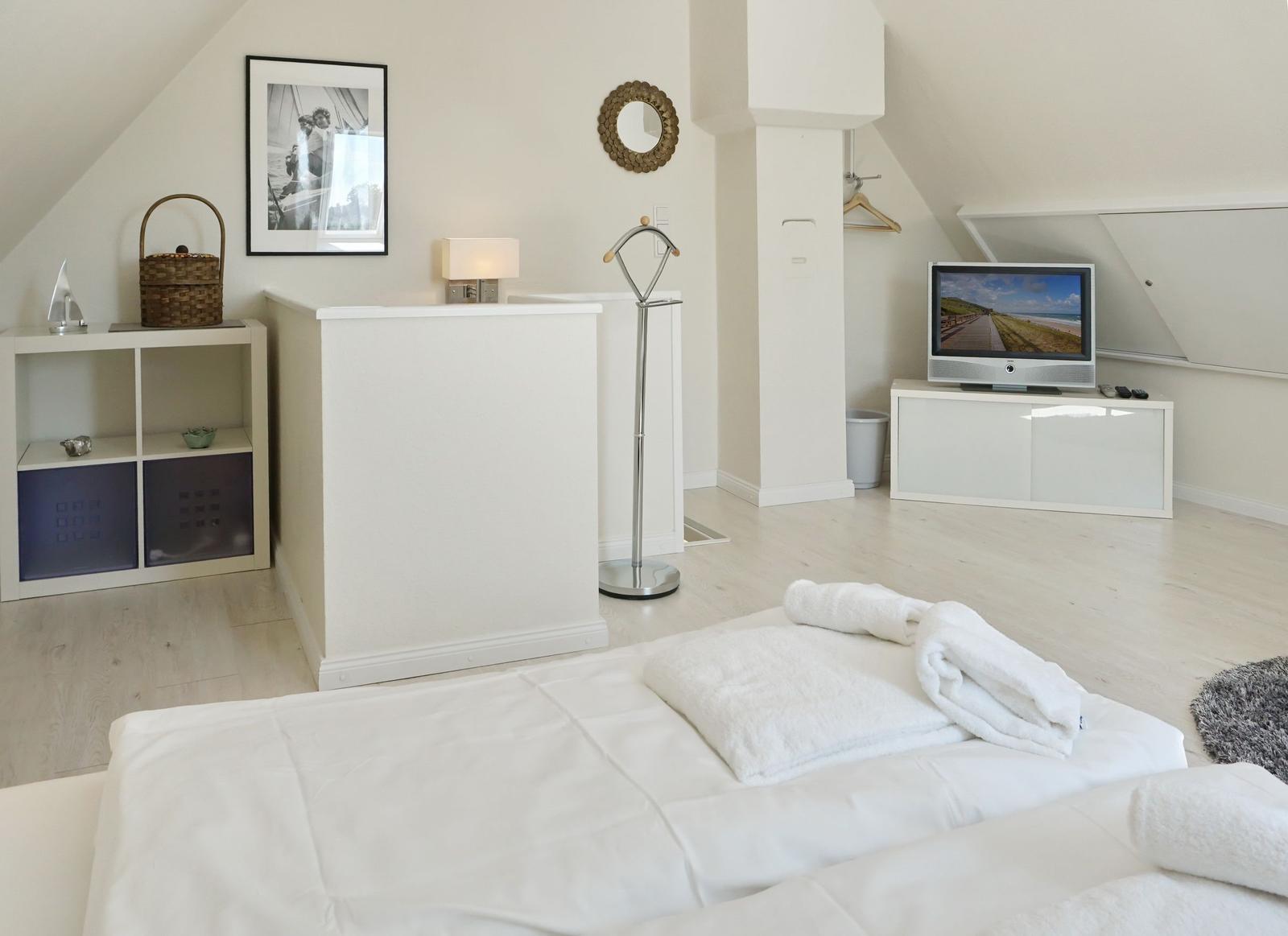 Bedroom with bed, TV, and wardrobe.