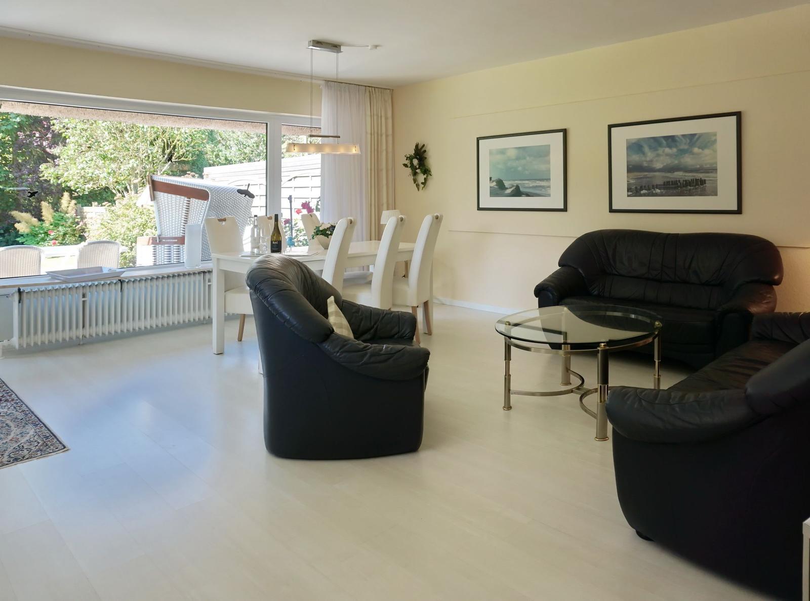 Living and dining area with black leather furniture and large window to terrace.