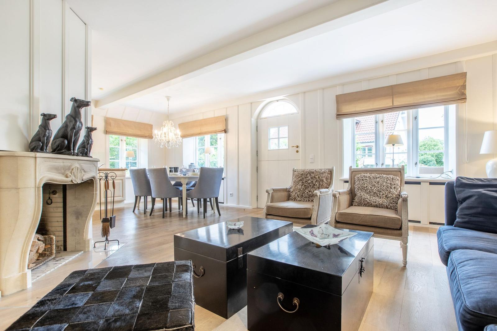 Living and dining area with fireplace, seating, and windows.