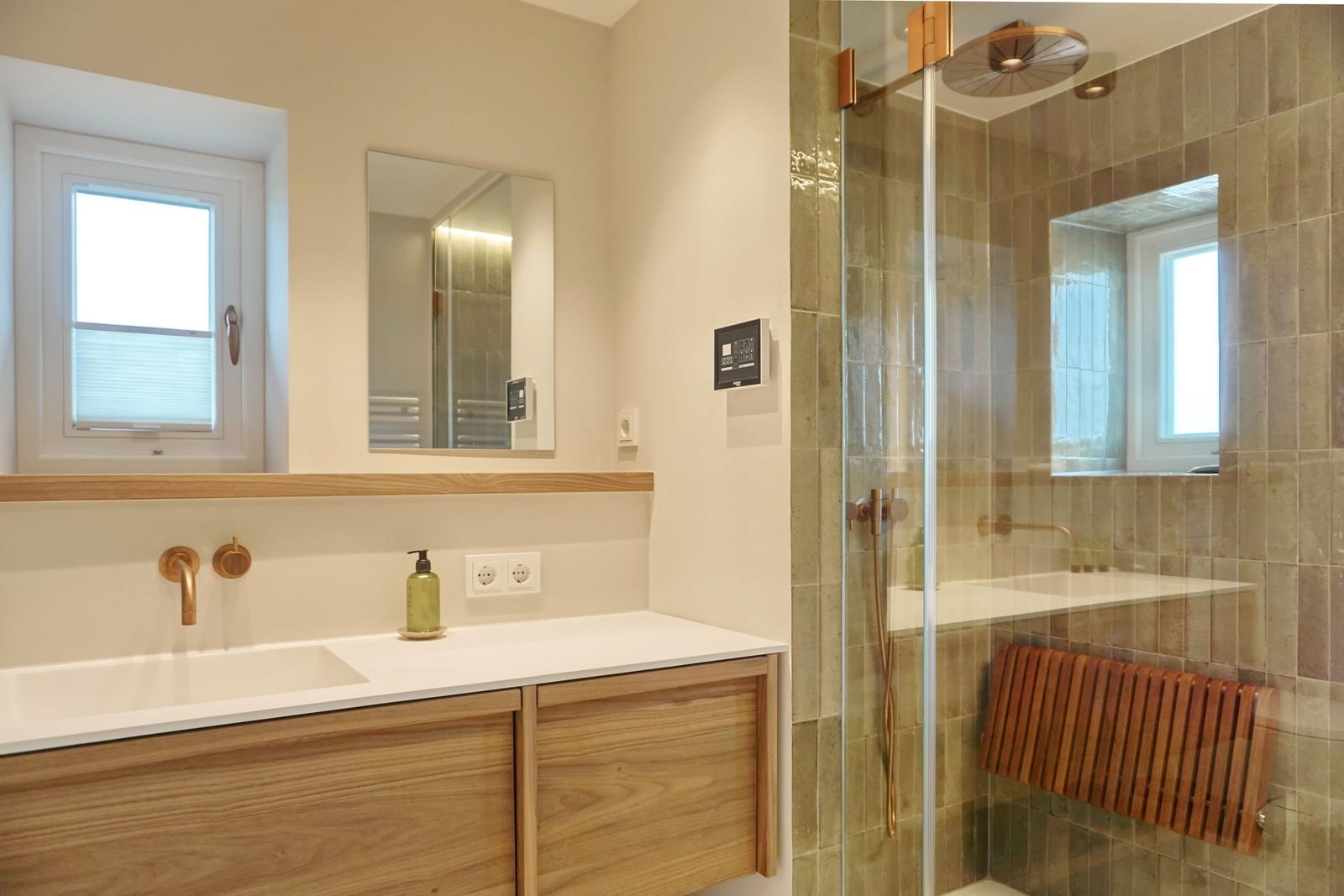 Badezimmer mit Dusche, Waschbecken und Fenster