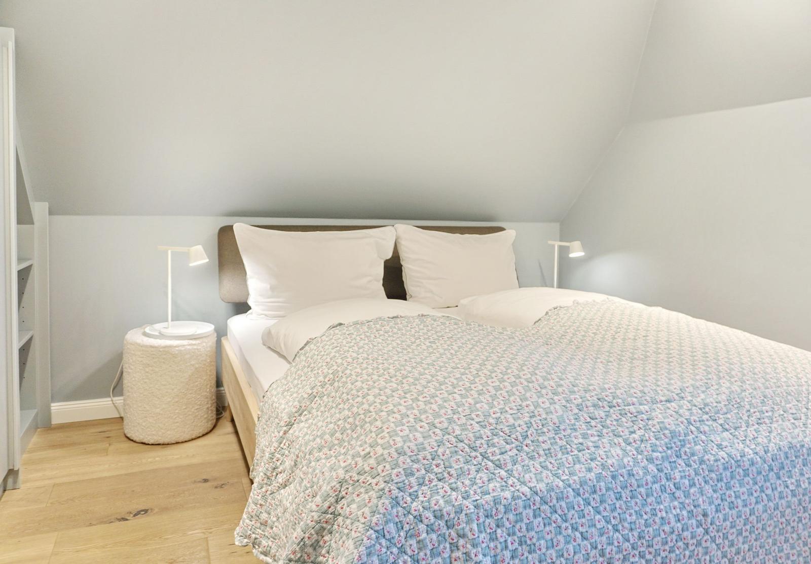 Schlafzimmer mit Doppelbett, zwei Nachttischen und Holzboden.
