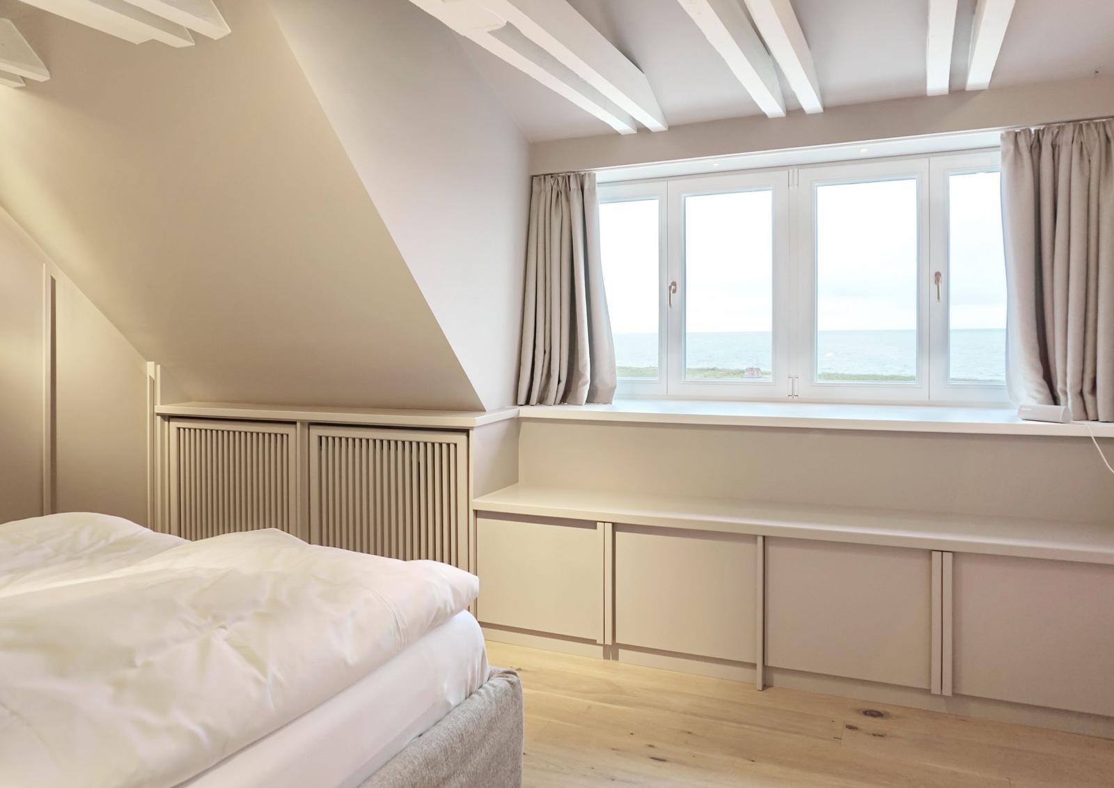 Schlafzimmer mit Blick aufs Meer und Dachschräge