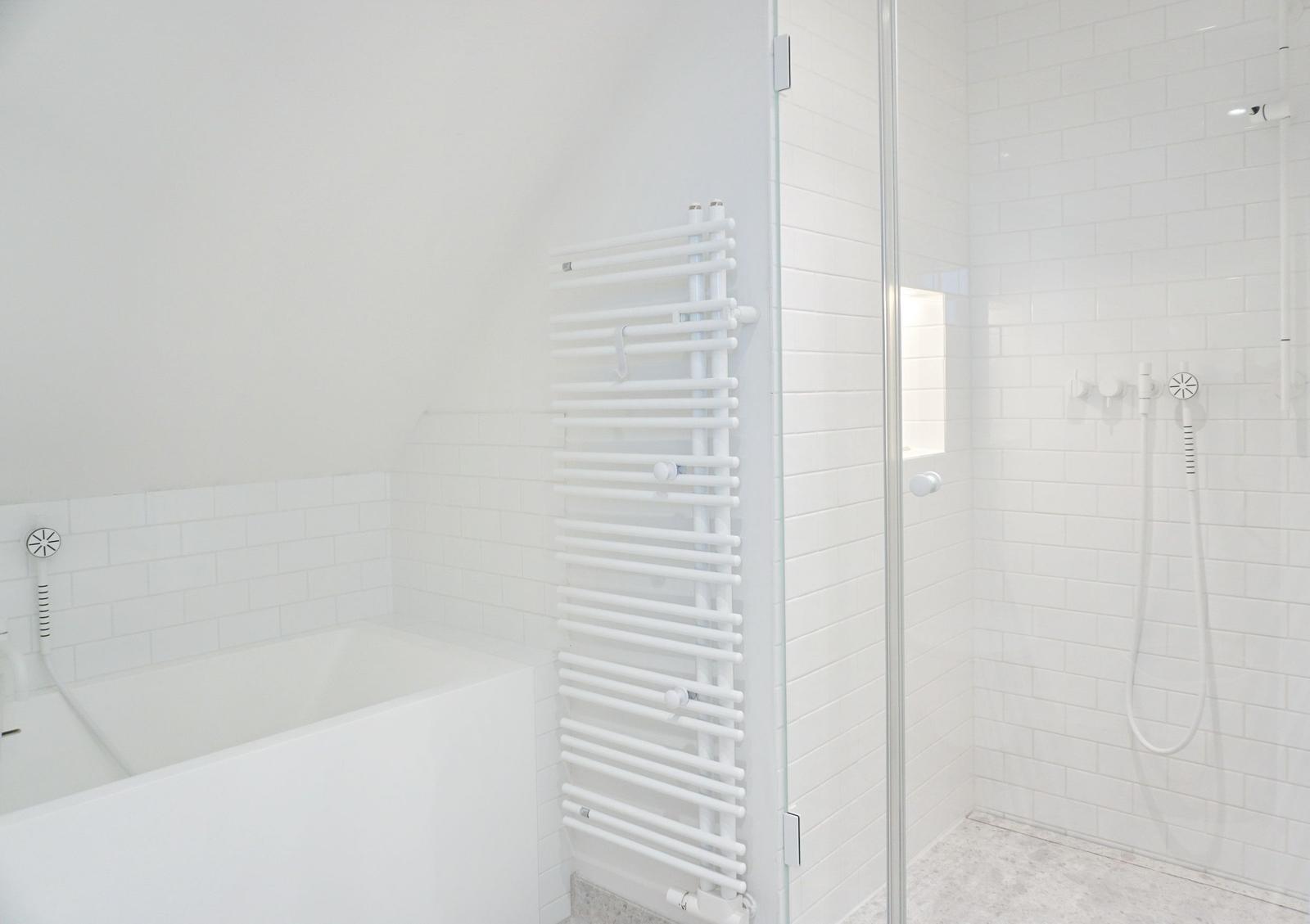 Badezimmer mit Badewanne und Dusche mit Glaswand.