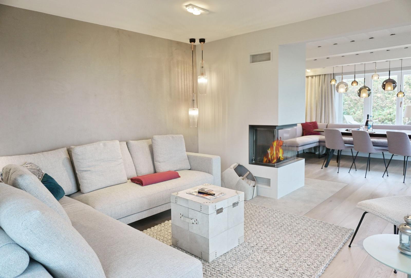 Wohnzimmer mit Sofa, Kamin und Essbereich