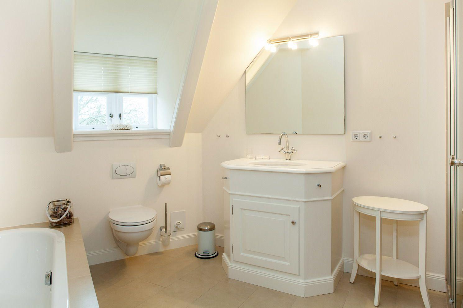 Badezimmer mit Waschbecken, Toilette, Badewanne und Spiegelschrank.