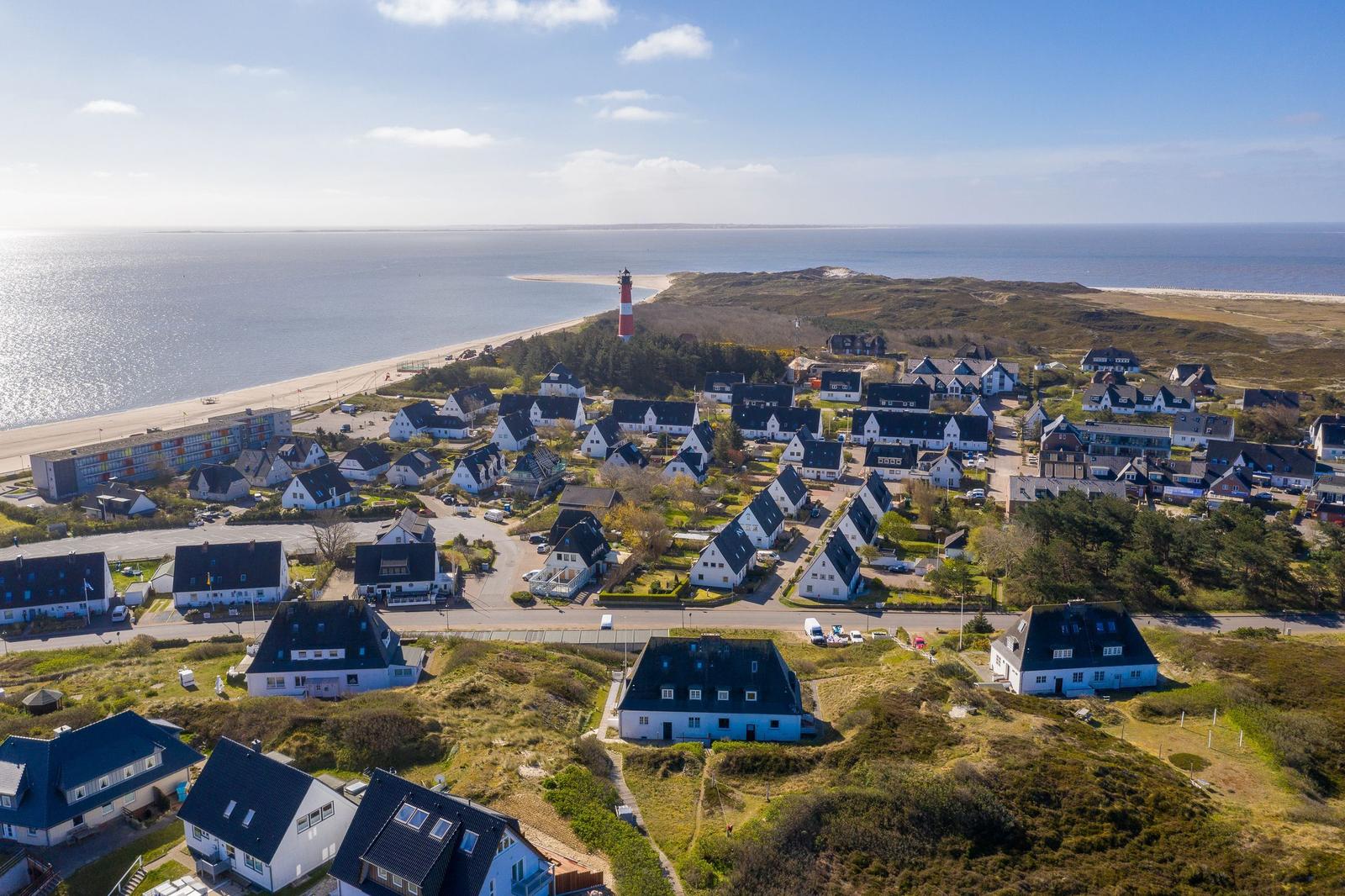 Village with beach and lighthouse by the coast