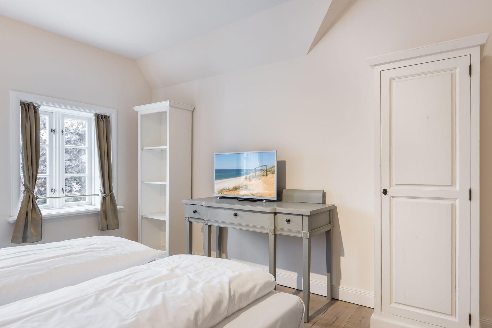Schlafzimmer mit Doppelbett, Schreibtisch und Fenster mit Blick.