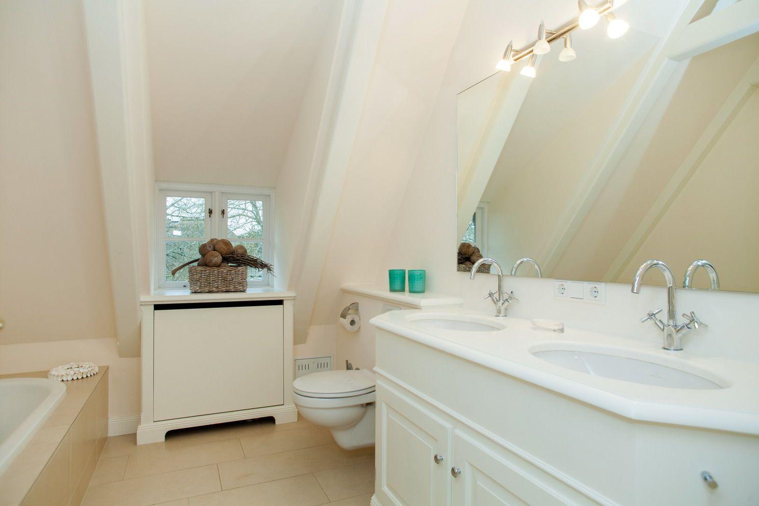 Bathroom with double sink, mirror, and window