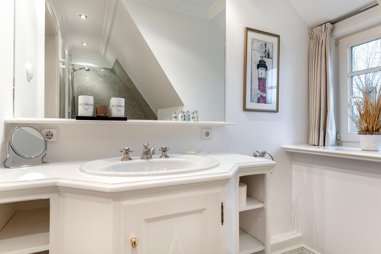 Badezimmer mit Waschbecken, Spiegel und Fenster